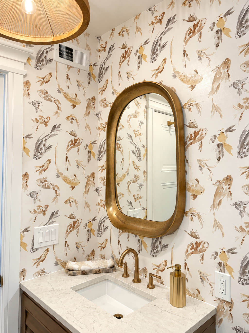 Residential wallpaper installation by RGT Wallpaper — koi-patterned wallcovering in a powder room with brass mirror and marble vanity